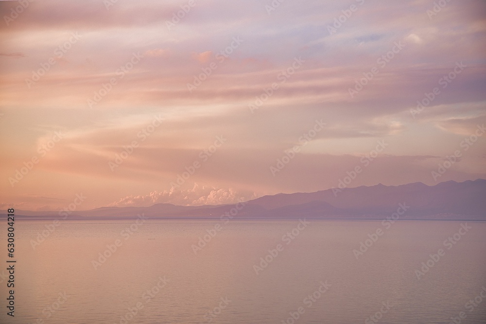 Tranquil lake view with majestic mountains in the distance at sunset
