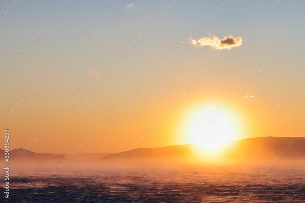 Fototapeta premium Beautiful sunset over the ocean with the sun behind it