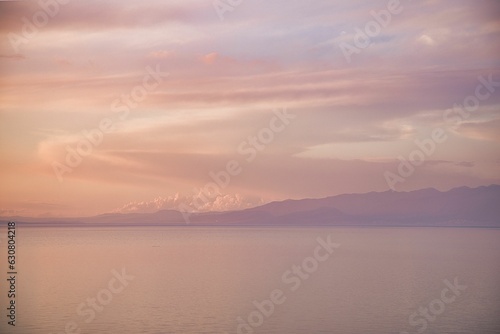 Tranquil lake view with majestic mountains in the distance at sunset