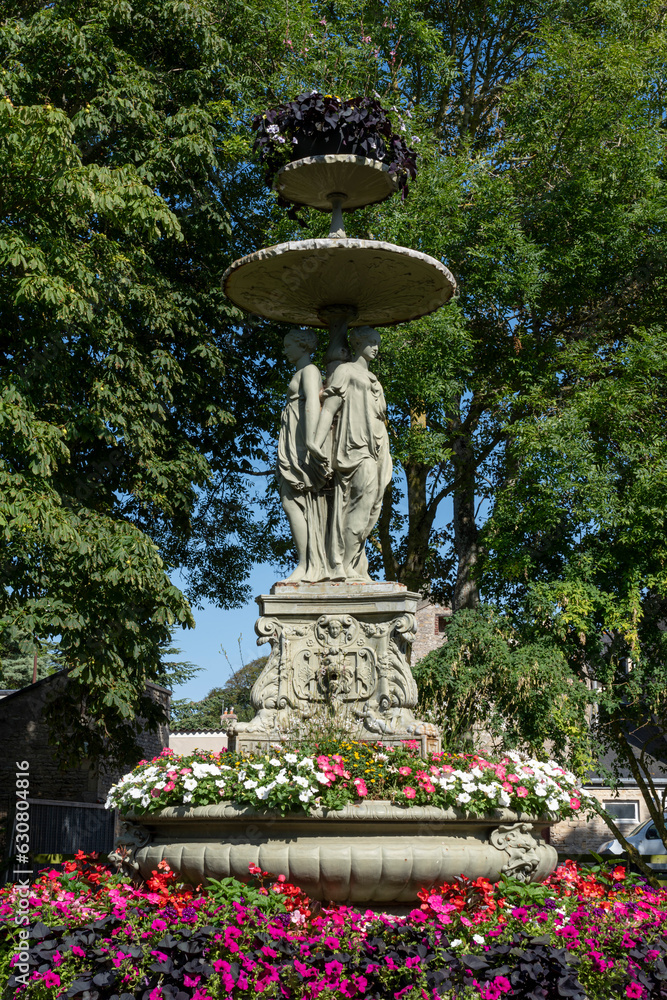 Fototapeta premium Langrune-Sur-Mer, France - 07 18 2023: View of the fountain of the three graces in the park of the town hall of Langrune-Sur-Mer