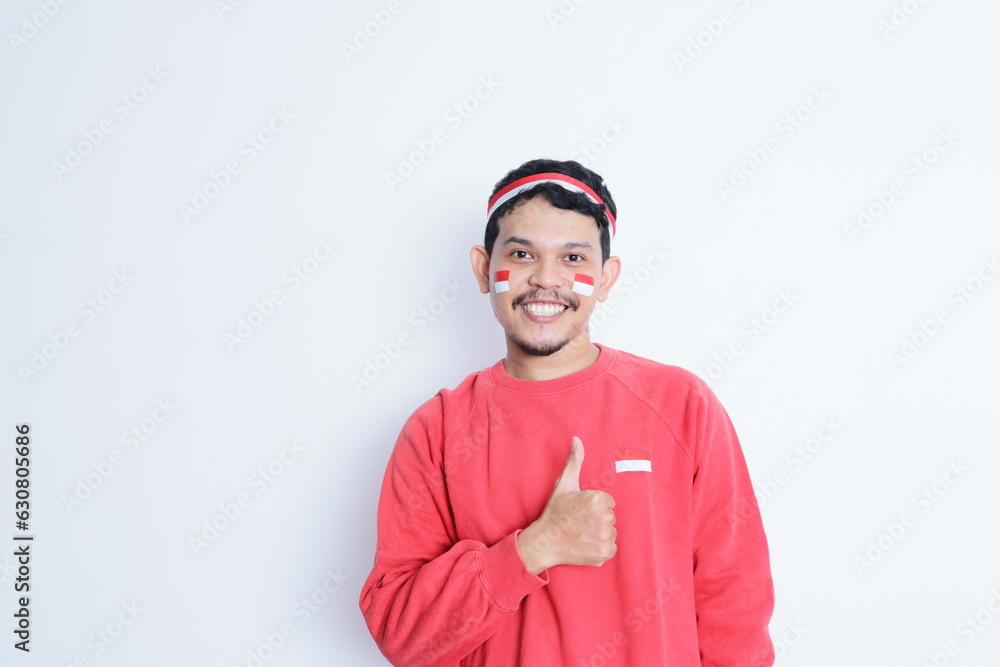 Indonesian man showing excitement with thumbs up when celebrating independence day Indonesian man showing excitement with thumbs up when celebrating independence day