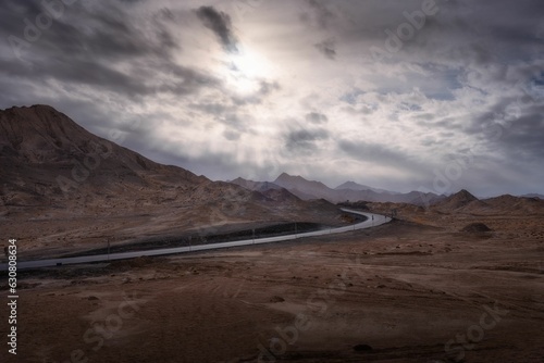 Landscape of a road in a deserted area under a cloudy sky in the evening © Yang6/Wirestock Creators