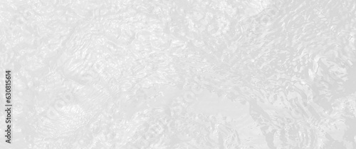 Ripple water texture on white background, shadow of water on sunlight, white water with ripples on the surface, defocus blurred transparent white colored clear calm water surface texture.