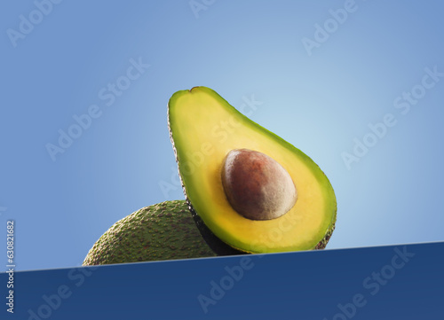 Half of freesh green avocado blue background hero view photo