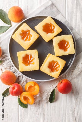 Italian apricot jam pie Cuor di tenerezza close-up on a plate on the table. Vertical top view from above photo