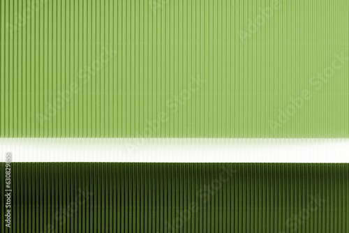 Light green and dark green corrugated paper texture. Geometric shapes and lines. Minimalist background. Flat lay. Copy space.