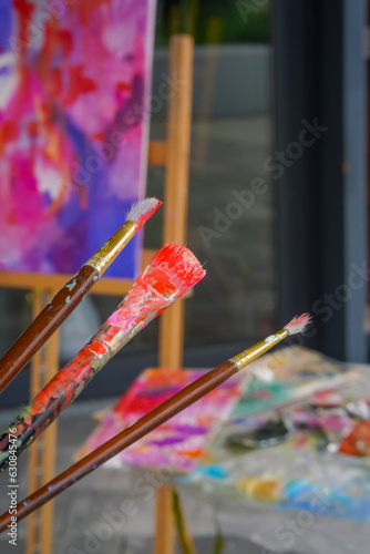 Close-up of three painting brushes of different sizes in paint the concept of admiration for a oil painting