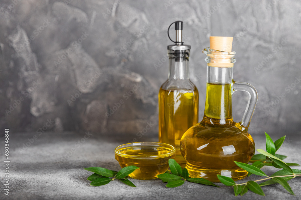 Olive oil in a bottle and gravy boat on the kitchen table. Oil bottle with branches and fruits of olives. Place for text. copy space. vegetable oil and salad dressing. Olive oil in a bottle and gravy boat on the kitchen table. Oil bottle with branches and fruits of olives. Place for text. copy space. vegetable oil and salad dressing.