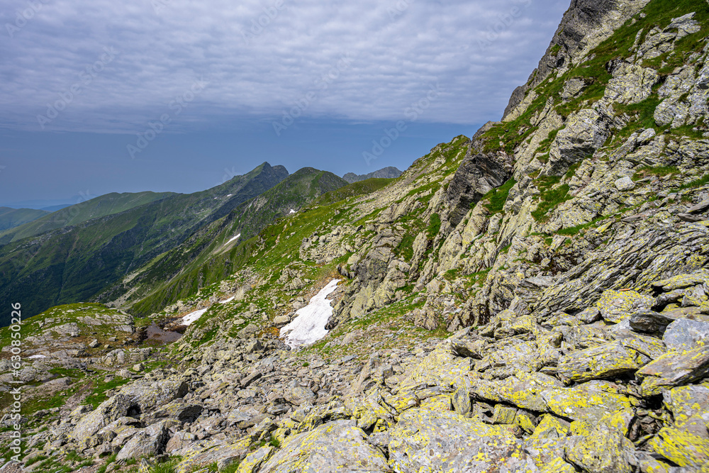 Summer landscape of the Fagaras Mountains. View from the hiking trail from Lake Balea to Mount Negoiu. Amazing rock formations of the Carpathians, Romania. Summer landscape of the Fagaras Mountains. View from the hiking trail from Lake Balea to Mount Negoiu. Amazing rock formations of the Carpathians, Romania.