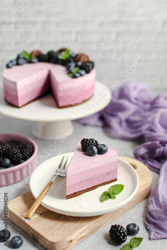 Blueberry Ombre cake. Delicious summer dessert decorated with fresh blueberries, blackberries, chocolate biscuits and mint leaves. Purple color.