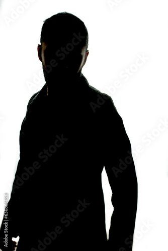 silhouette of man in trench coat on bright white background. white background. black silhouette of a person looking back. erect and strong pose of man silhouette. 