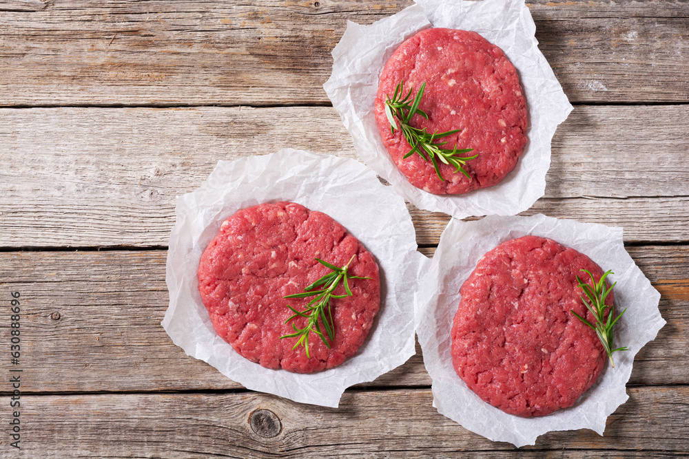 Raw cutlet for beef hamburger on wooden background