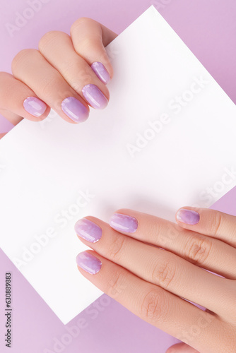 Female hands with trendy manicure holding postcard