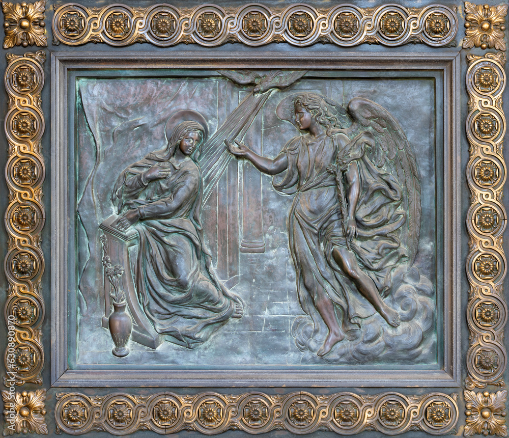 NAPLES, ITALY - APRIL 22, 2023: The bronze relief of Annunciation on the gate of church Basilica dell Incoronata Madre del Buon Consiglio from 20. cent.	
