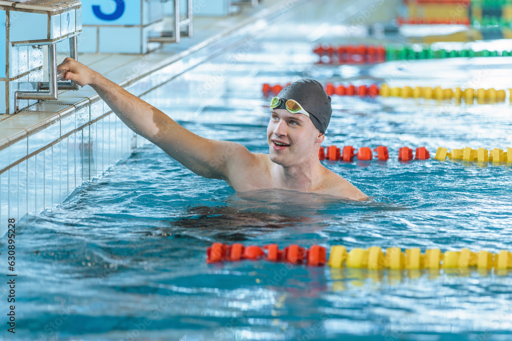 Man swimmer happy at the finish of a race in the pool at competition