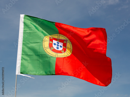 Close-up picture of national flag of Portuguese Republic on blue sky background photo