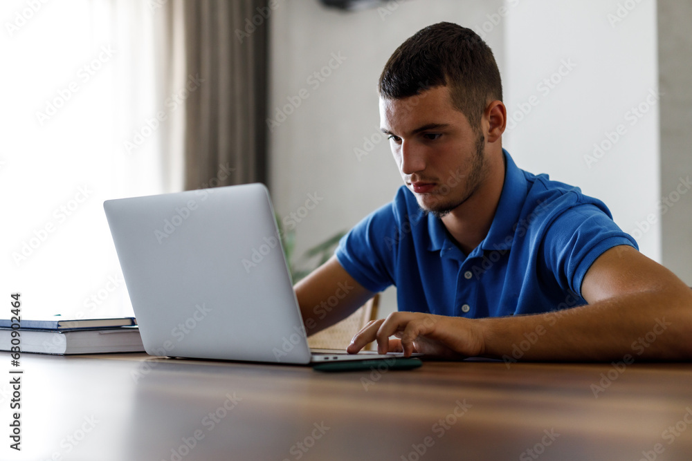 Teenage boy using laptop and doing homework Teenage boy using laptop and doing homework