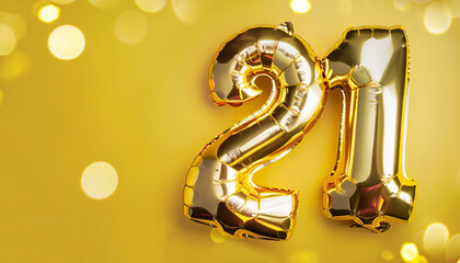 Banner with number 21 golden balloons with copy space. Twenty-one years anniversary celebration concept on a yellow background with shiny bokeh.