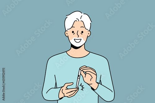 Elderly man uses glucometer to measure level insulin in blood and smiles, rejoicing at easing diabetes. Gray-haired grandfather with glucometer recommends fighting diabetes and taking care of health