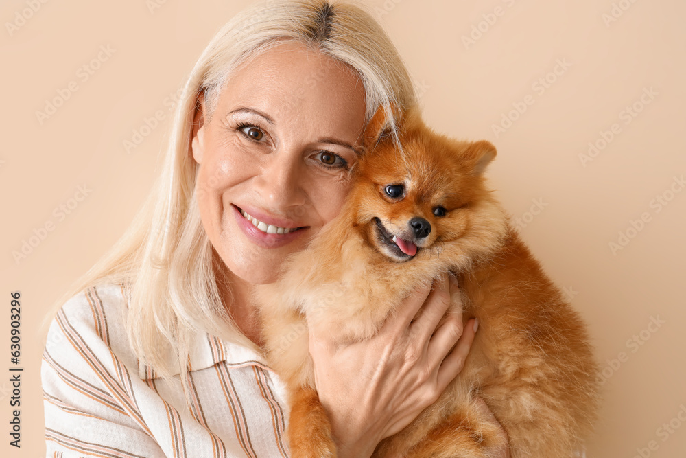 Mature woman with Pomeranian dog on beige background, closeup Mature woman with Pomeranian dog on beige background, closeup