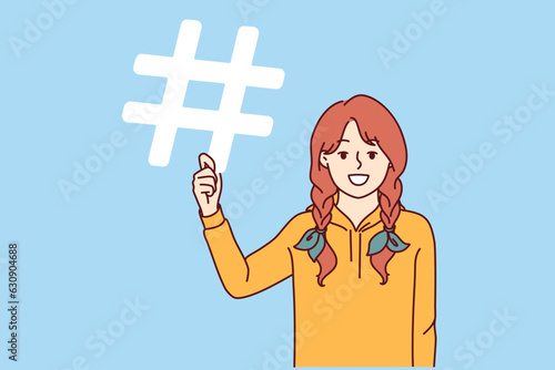 Little girl is holding hashtag symbol offering to use sign to tag friends or events in social media posts. Schoolgirl with hashtag recommends making link and using special sign for relinking