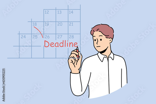 Business man fills in calendar and makes note of deadlines so as not to miss day of reporting to customer. Guy works as team leader and keeps track of deadlines for data to complete tasks.