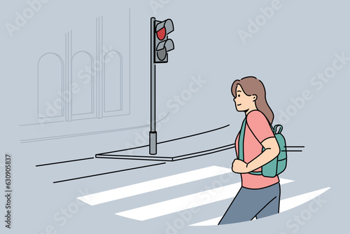 Woman pedestrian crosses road at red traffic light, putting own life and health of car drivers at risk. Girl demonstrates lack of civic consciousness by breaking rules when crossing road
