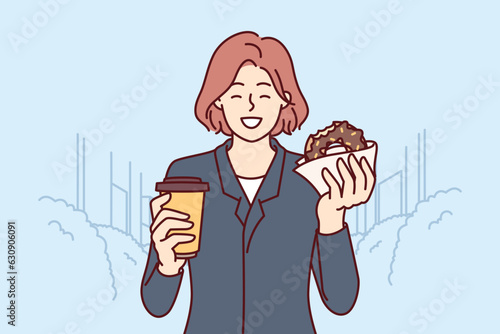 Business woman having breakfast donut and drinking coffee standing on city street and enjoying dessert on way to work. Happy girl eating breakfast on go buying takeaway food at bakery