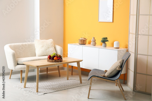 Interior of living room with fruit basket on table and sofa