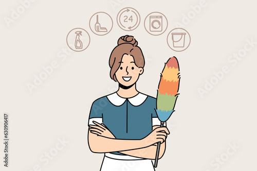 Woman housekeeper or maid with dust brush smiles and looks at screen recommending contacting cleaning company. Maid girl provides services for cleaning apartment or hotel rooms and washing clothes