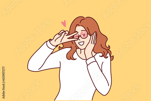 Coquettish woman puts hand to ear and winks, wanting to meet or seduce passerby she likes. Coquettish young girl makes gestures to attract attention of boyfriend and arrange phone call.