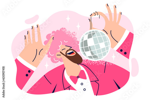 Dancing man with pink wig on head is holding disco ball and enjoying discotheque or music party