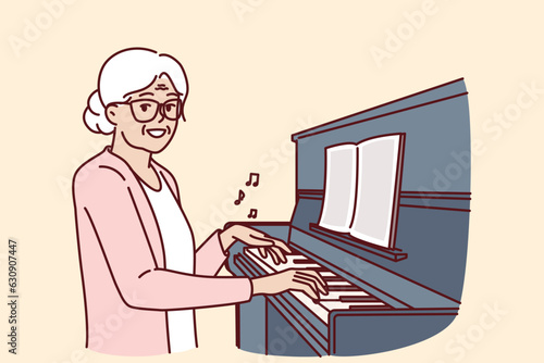 Elderly woman plays piano and smiles, rejoicing at presence of creative hobby. Happy grandmother sitting near pianoforte or piano and doing tutoring and learning to play musical instruments