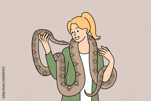Woman with long snake around neck smiles enjoying communication with beloved pet boa constrictor. Girl holds dangerous predatory snake and does not feel fear at sight of poisonous python
