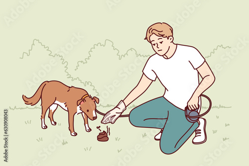 Man walking dog puts excrement in plastic bag so as not to pollute park. Young guy dog owner shows conscientiousness cleaning up after puppy and taking care of cleanliness of surrounding area