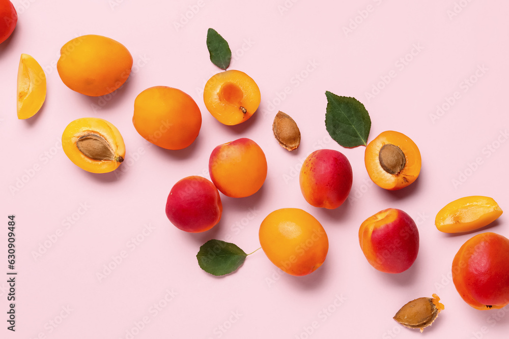 Sweet apricots and leaves on pink background Sweet apricots and leaves on pink background