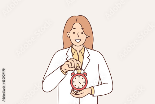 Woman doctor holding alarm clock recommending sticking to schedule for taking medications