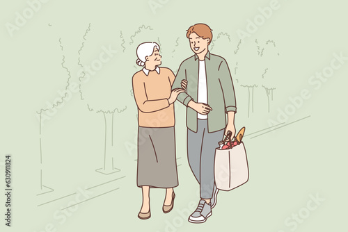 Young man helps old woman to carry heavy bag from grocery store, for concept respect for pensioners
