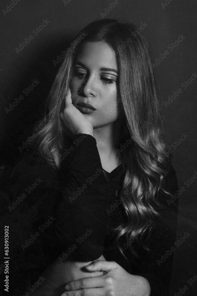 portrait of a woman looking down in front of the camera in black and white. portrait of a woman looking down in front of the camera in black and white.