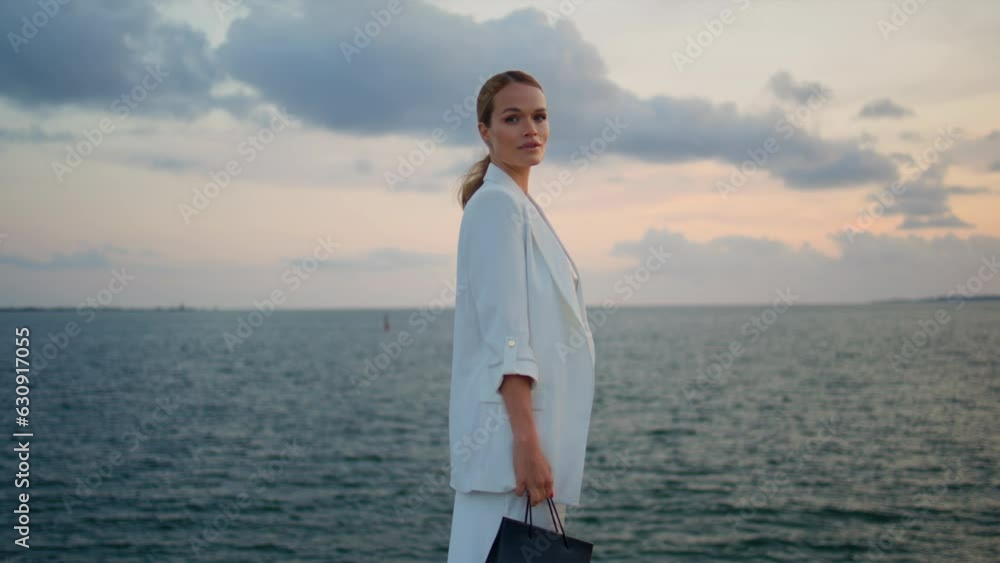Elegant woman enjoy seascape standing in front cloudy sky. Lady looking sunset Elegant woman enjoy seascape standing in front cloudy sky. Lady looking sunset