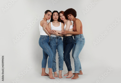 Group of beautiful young women on light grey background
