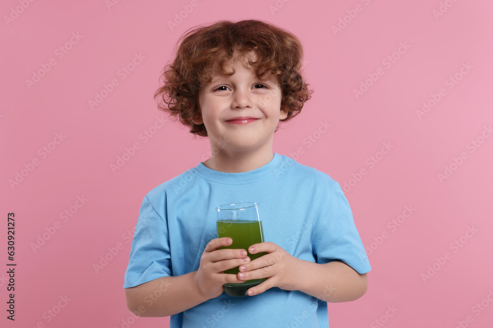 Cute little boy with glass of fresh juice on pink background Cute little boy with glass of fresh juice on pink background