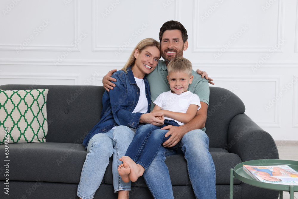 Portrait of happy family with child on sofa at home Portrait of happy family with child on sofa at home