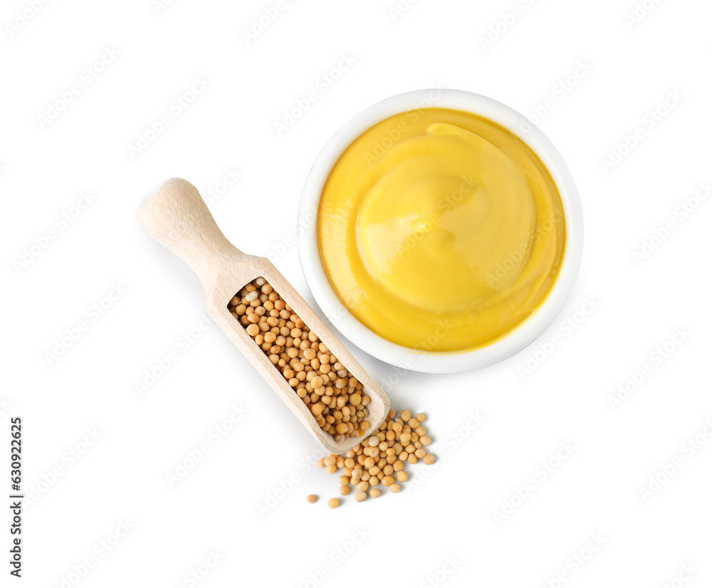 Bowl of delicious mustard and scoop with seeds on white background, top view Bowl of delicious mustard and scoop with seeds on white background, top view