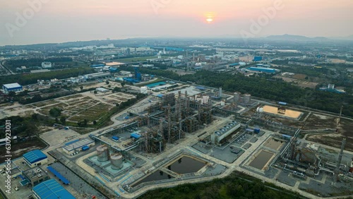 Drone Hyperlapse time lapse of petroleum oil refinery in industrial estate at evening, drone aerial view sunset. petrochemical factory industry, or environmental air pollution.
