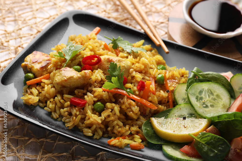 Tasty rice with meat and vegetables in plate near soy sauce on white table, closeup Tasty rice with meat and vegetables in plate near soy sauce on white table, closeup