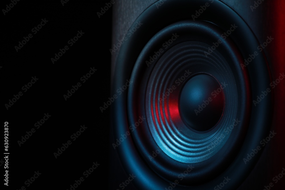 One sound speaker in neon light on black background, closeup. Space for text