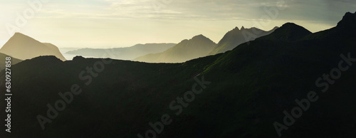 Panorama of abstract norwegian landscape at sunset, Smaltinden, Luröy, Helgeland, Nordnorge. Post summer storm dusk with mountain silhouettes. Green details in dark mountains scandinavia. Sommarnatt photo