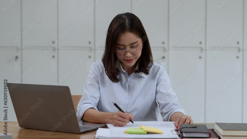 Asian Businesswoman Using laptop computer and working at office with document on desk. Asian Businesswoman Using laptop computer and working at office with document on desk.