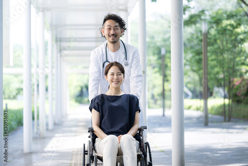 車椅子に乗る女性とドクター カメラ目線